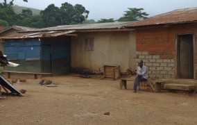 Man sitting outside a house in Conakry, Guinea