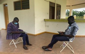 Ghana MIGNEX team conducting field research training outside using COVID-19 safe measures such as mask wearing and social distancing.